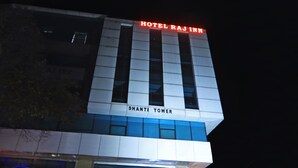 Un edificio con un letrero que dice "HOTEL RAJ INN" y "SHANTI TOWER".