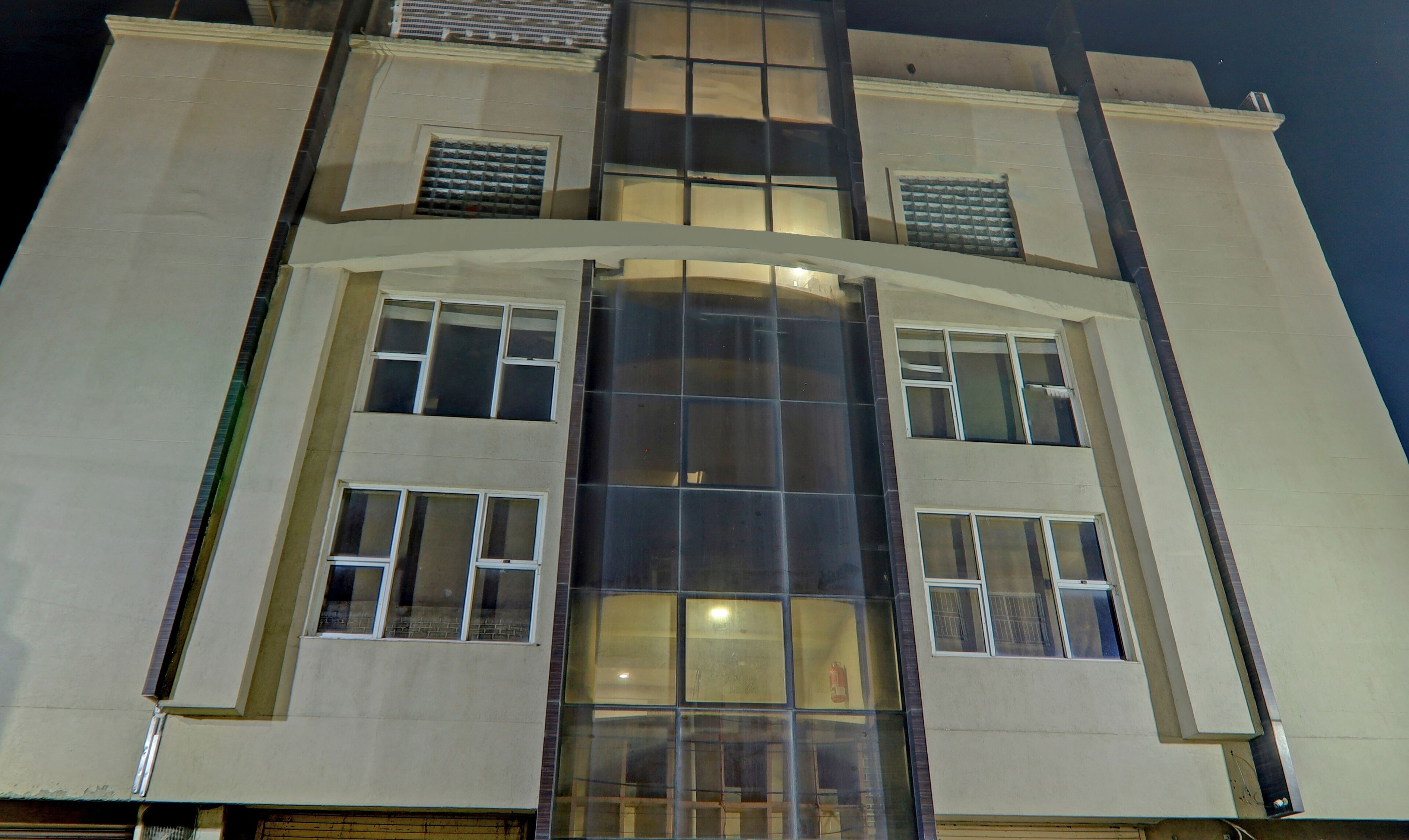 A multi-story building with large windows and a central glass facade.