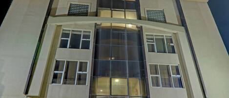 A multi-story building with large windows and a central glass facade.
