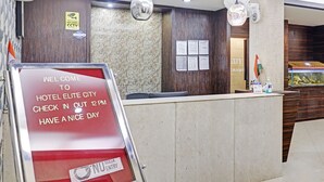 Zona de recepción de un hotel con un letrero rojo que indica el horario de registro y la obligatoriedad de usar mascarilla.