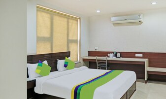 Habitación de hotel con cama, escritorio y aire acondicionado.