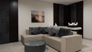 Een moderne woonkamer met een hoekbank, een glazen salontafel en een schilderij aan de muur.
