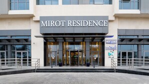 Een modern gebouw met een bord waarop 'MIROT RESIDENCE' staat.