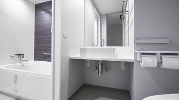 Een moderne badkamer met een bad, wastafel en toilet.