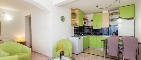 Un espacio habitable pequeño con cocina, comedor y asientos.