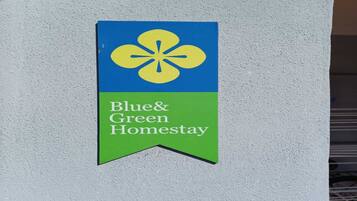A Blue & Green Homesstay sign on a wall.