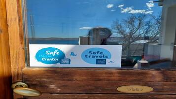 Una puerta de madera con un cartel que indica 'Safe travels by World Tourism Council' y una placa con el nombre 'Paola 2'.