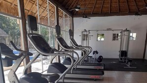 A gym with treadmills, weight machines, and a ceiling fan. - Devoted Hoestel in Cancun With Equipped Kitchen, Pool, Close to Beaches & More! (Cancun)