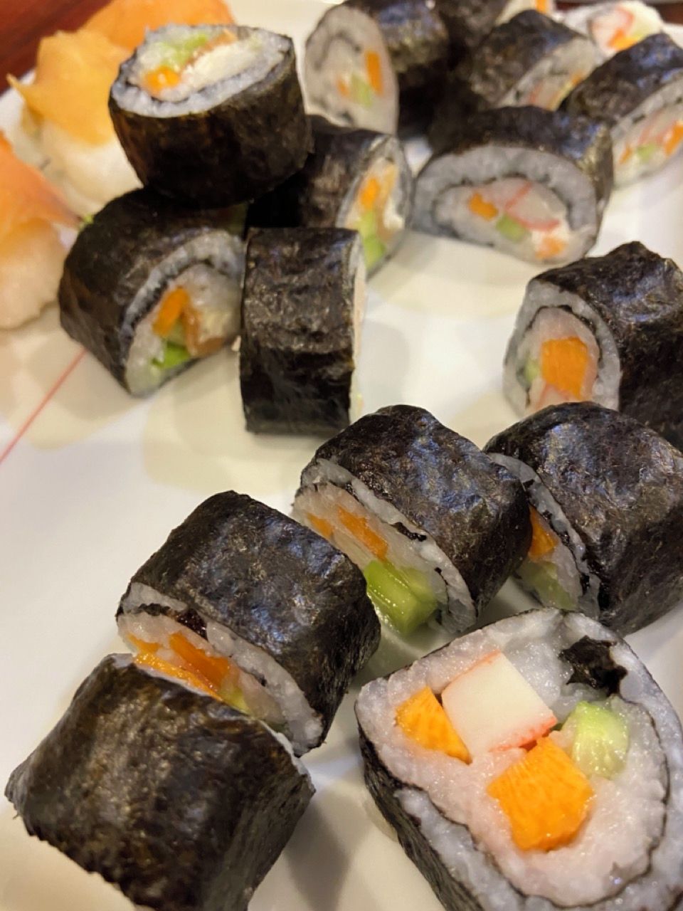 Un piatto di involtini sushi con diversi ripieni.