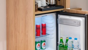 A compact kitchen area with a built-in refrigerator and a coffee maker. - Starla Studios (Athens)