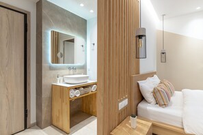A modern bathroom with a wooden vanity, a large mirror, and a built-in sink.