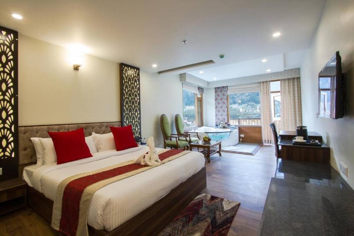 Amplia habitación de hotel con una cama grande, un comedor y vistas a la ciudad.