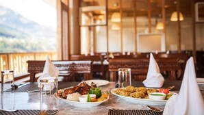 Un restaurant offrant une vue sur la montagne, doté de meubles en bois et proposant une grande variété de plats.