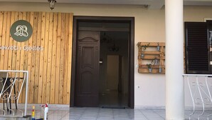 Une entrée d’immeuble avec une façade en bois, une porte et un petit panneau.