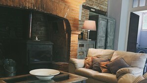 Un salón acogedor con chimenea de ladrillo, un sofá de cuero y una mesa de centro de madera.