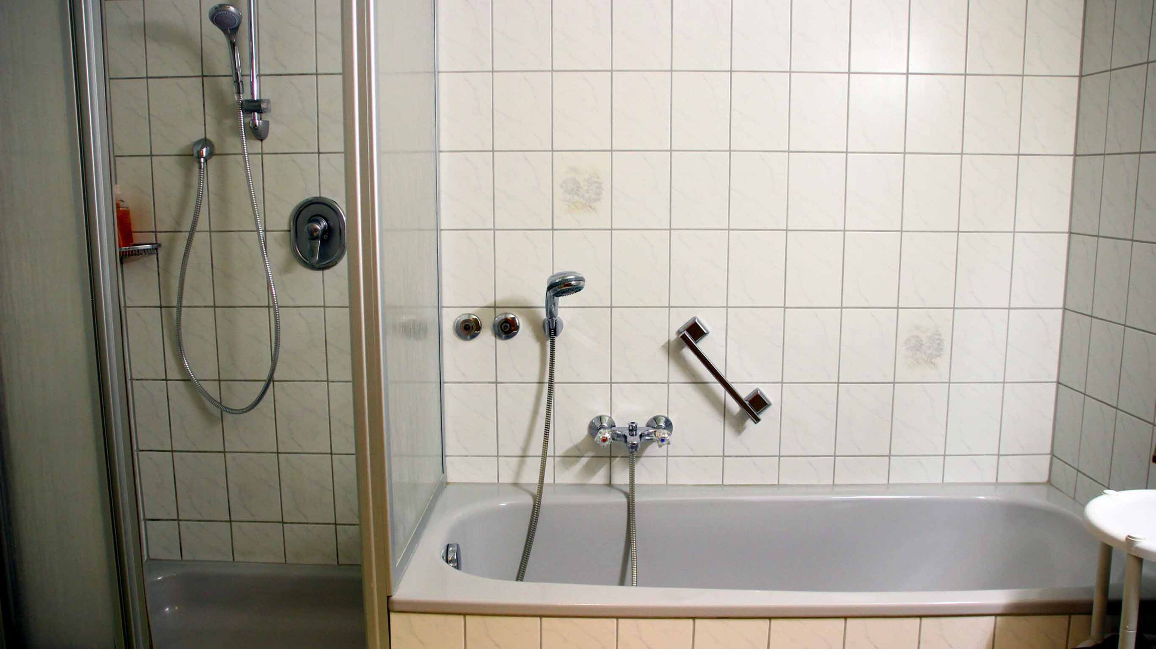 Un baño con ducha, bañera y retrete.