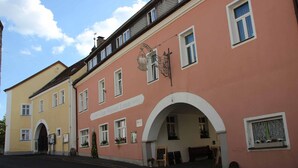 A building with a pink facade and a sign reading "Zum Weissen Lamm Hotel." - Hotel Gasthof Zum weissen Lamm (Hohenberg a.d.Eger)