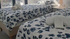 A bedroom with two beds, a window with a view of the landscape, and a bedside table with a lamp. - Apartment with sea and mountain view. HEATED POOL DURING THE WINTER MONTHS  (Nerja)