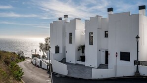 A white building with a curved driveway and a view of the ocean. - Apartment with sea and mountain view. HEATED POOL DURING THE WINTER MONTHS  (Nerja)