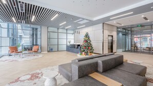 Eine moderne Lobby mit Weihnachtsbaum, grauen Sofas und einer Rezeption.