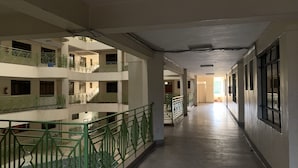 A multi-level corridor with balconies, a central open space, and a long hallway leading to an exit. - Immaculate 2-bed Apartment, Langata, Nairobi (Nairobi)