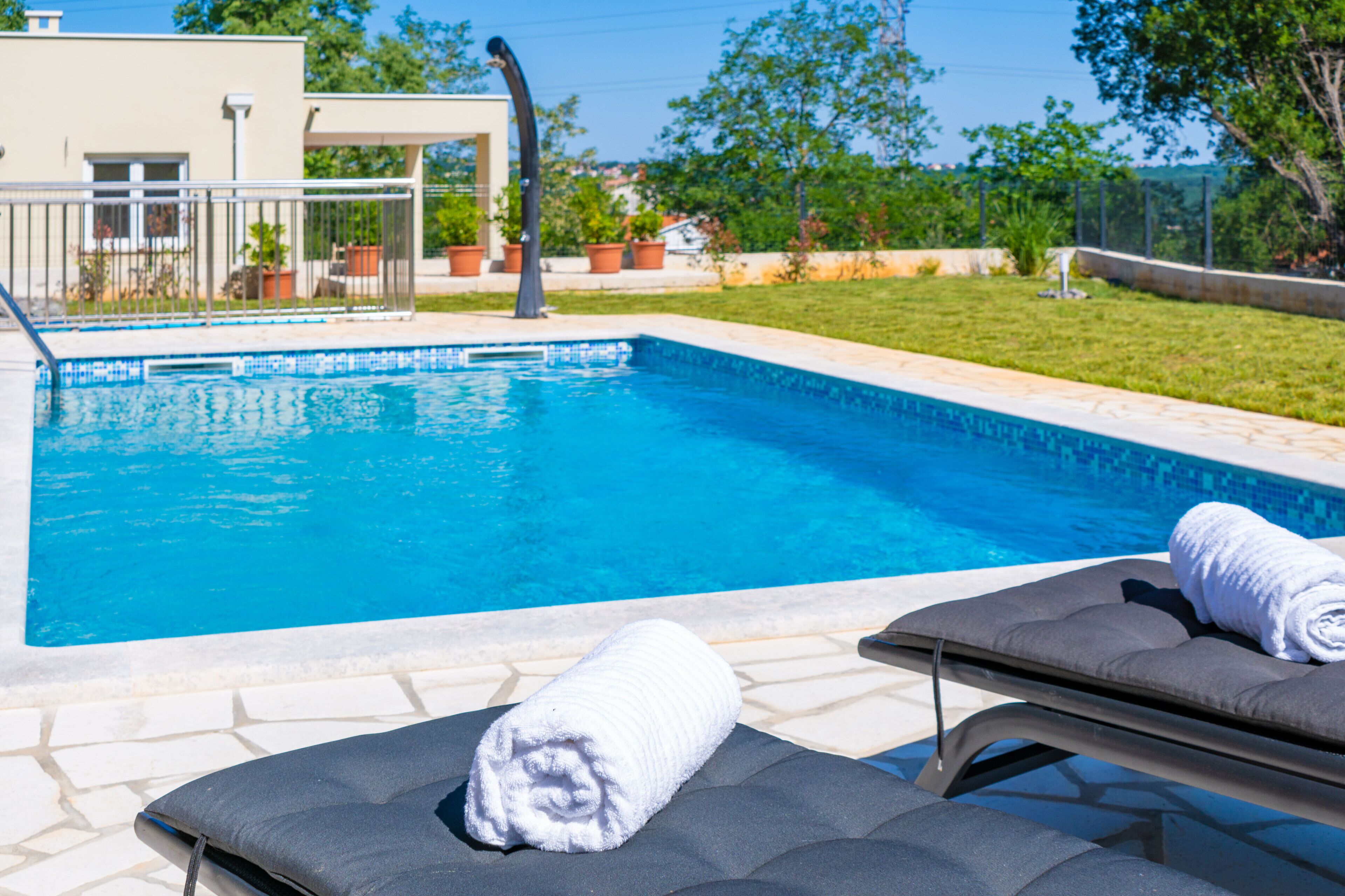 A swimming pool with lounge chairs and a towel.