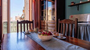 Una mesa de comedor con un bol de fruta, un croissant y una taza.