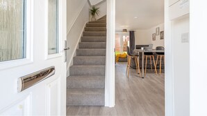 A staircase leading to a dining area with a table and chairs. - The Holt (Lincoln)