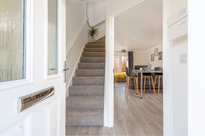 A staircase leading to a dining area with a table and chairs. - The Holt (Lincoln)