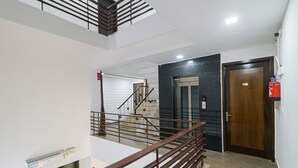 Un interior moderno con una escalera, un extintor y una puerta con un número.