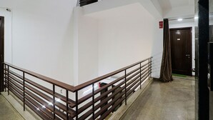 Un interior moderno con una escalera, baranda de madera y una puerta con un letrero.