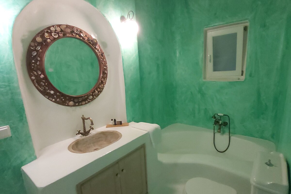 Un baño con lavamanos, espejo y bañera.