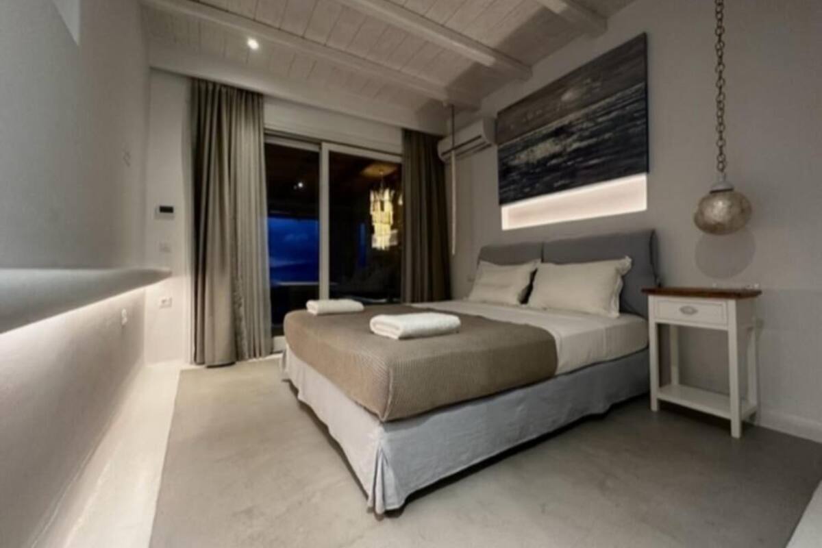 Een moderne slaapkamer met een groot bed, een nachtkastje en uitzicht op de omgeving.