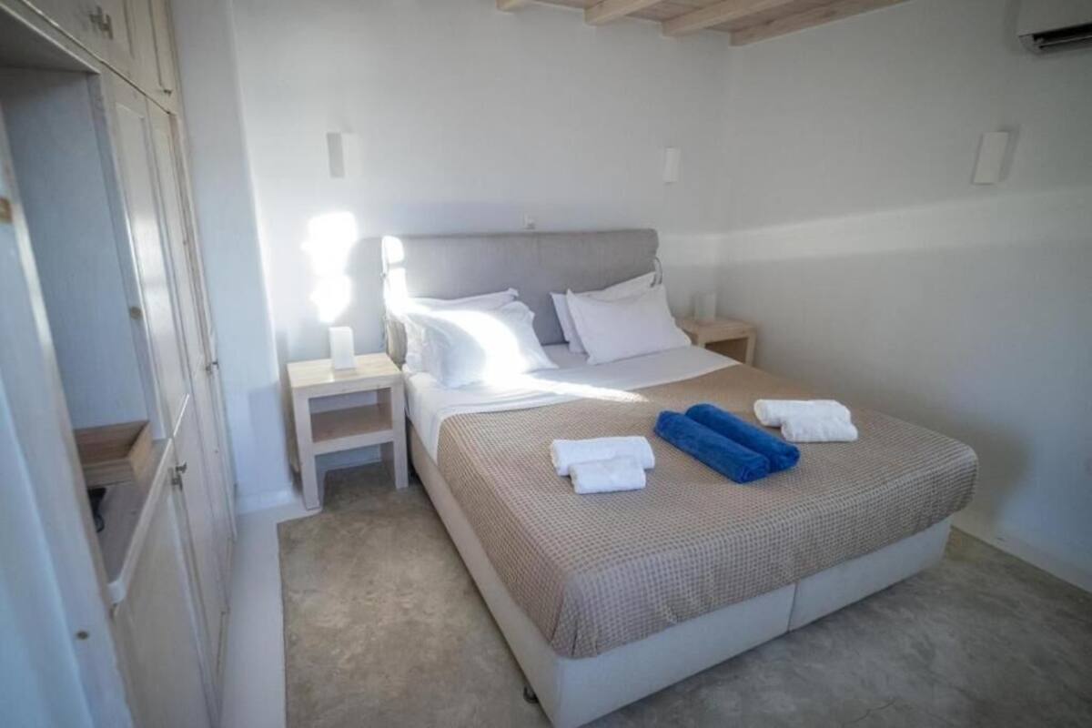 Een slaapkamer met een bed, nachtkastjes en een kledingkast.