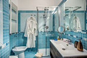 A bathroom with a glass shower enclosure, a white sink, and a bidet. - Honeymooners nest in Amalfi coast  (Marciano)