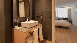 A modern bathroom with a large mirror, a white sink, and a wooden vanity. - Hotel Cortabitarte (Soria)