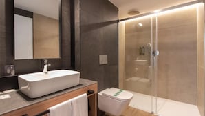 A modern bathroom with a large mirror, a vessel sink, a toilet, and a glass-enclosed shower area. - Hotel Cortabitarte (Soria)