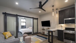 Un apartamento moderno con un dormitorio, sala de estar y cocina.