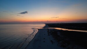 A beach with a calm sea and a clear sky at sunset. - End of Summer Sunset Views PPC3-401 (Panama City Beach)