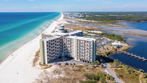 A high-rise hotel with multiple floors, a beach, and a marina. - End of Summer Sunset Views PPC3-401 (Panama City Beach)