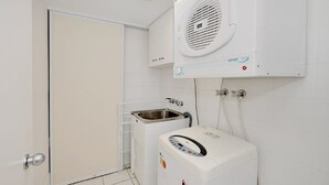 Una safareig petit i pràctic amb rentadora, assecadora i sistema de ventilació integrat.