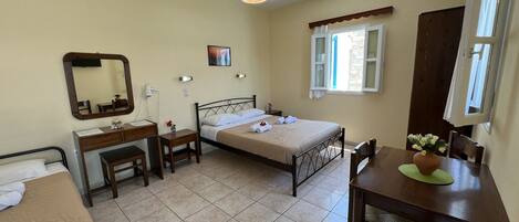 A bedroom with a bed, bedside table, chair, desk, and a dining table with chairs.