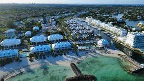 Ein Küstenresort mit mehreren weißen Gebäuden, einer Marina und einem Strand.