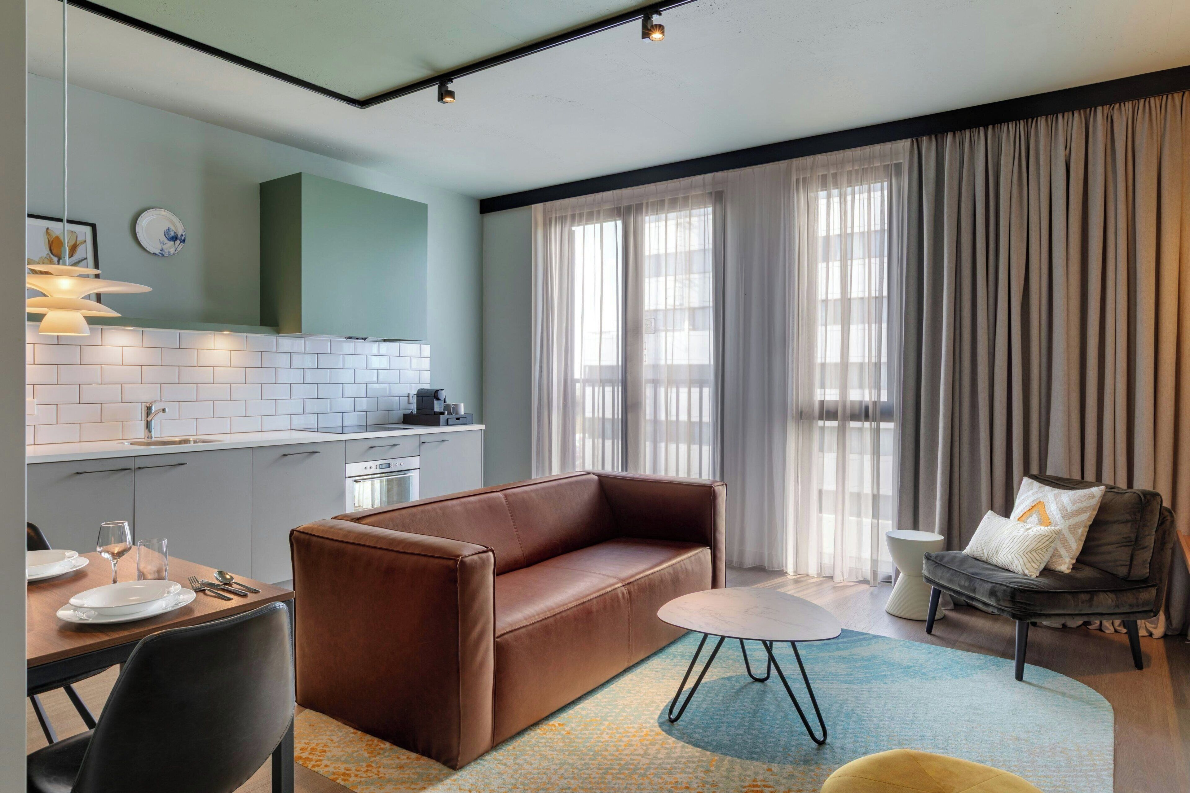 A modern living room with a sofa, a dining table, and a coffee table.