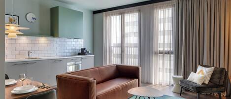 A modern living room with a sofa, a dining table, and a coffee table.