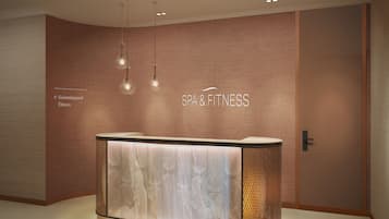 Welcome to our reception area, featuring a central desk with a spacious surface and directional signs pointing to the swimming pool and fitness areas.
