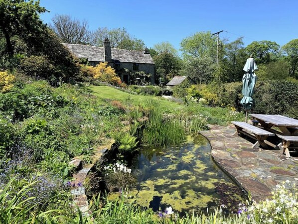 Escape to a serene garden oasis with a tranquil water feature and picturesque picnic area.