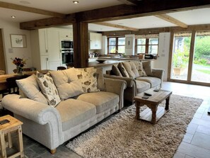 Relax in this inviting living area with a large sofa, wooden coffee table, and plush rug.