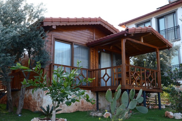 Guests can enjoy a balcony with a lattice design, surrounded by a lush garden featuring a variety of plants.