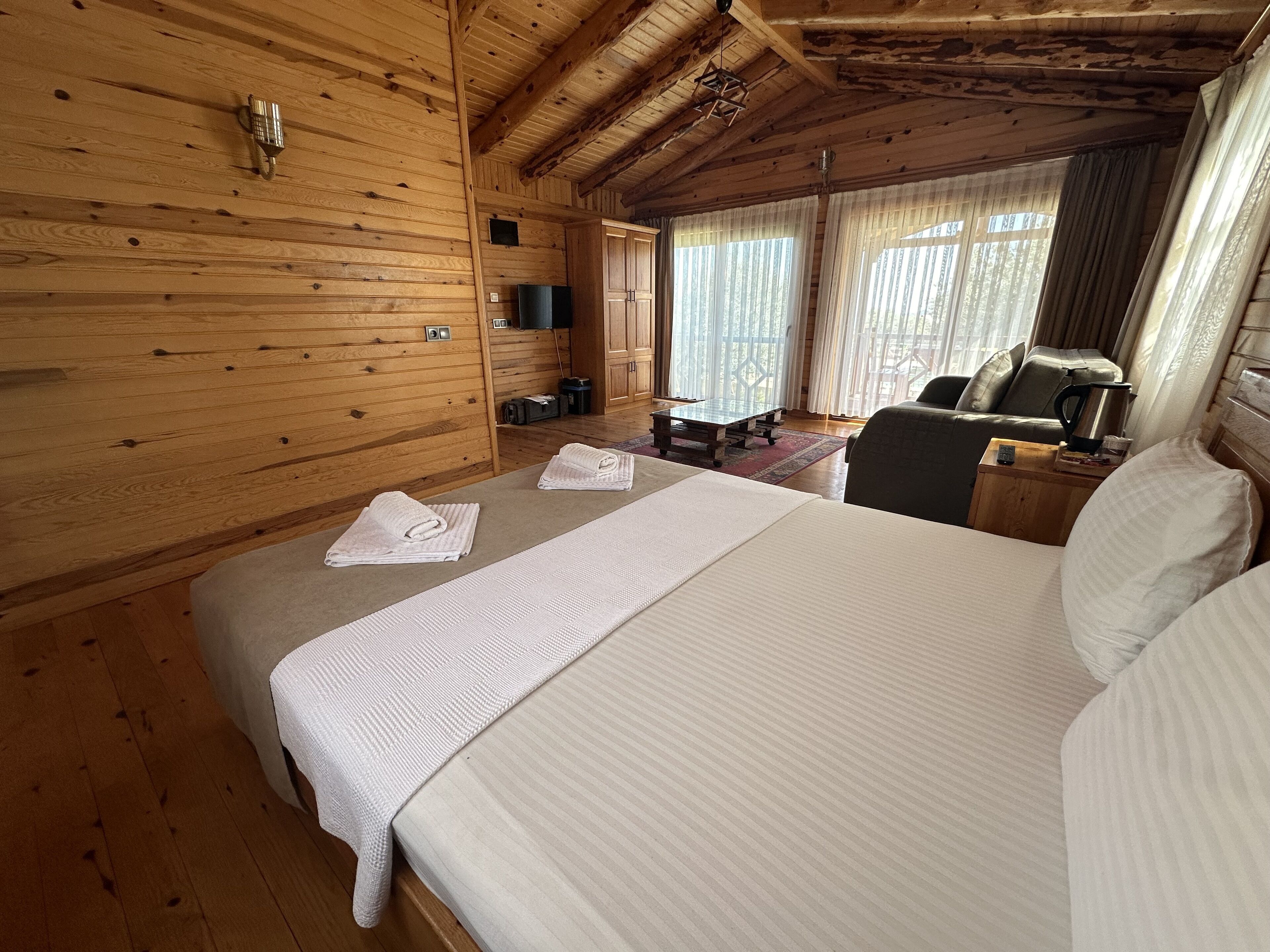 Une pièce de style cabane en bois, comprenant un lit, un bureau et une chaise.